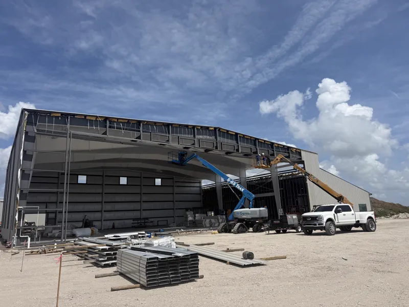 Steel hangar sheeted in, with a large open bay door and insulated liner