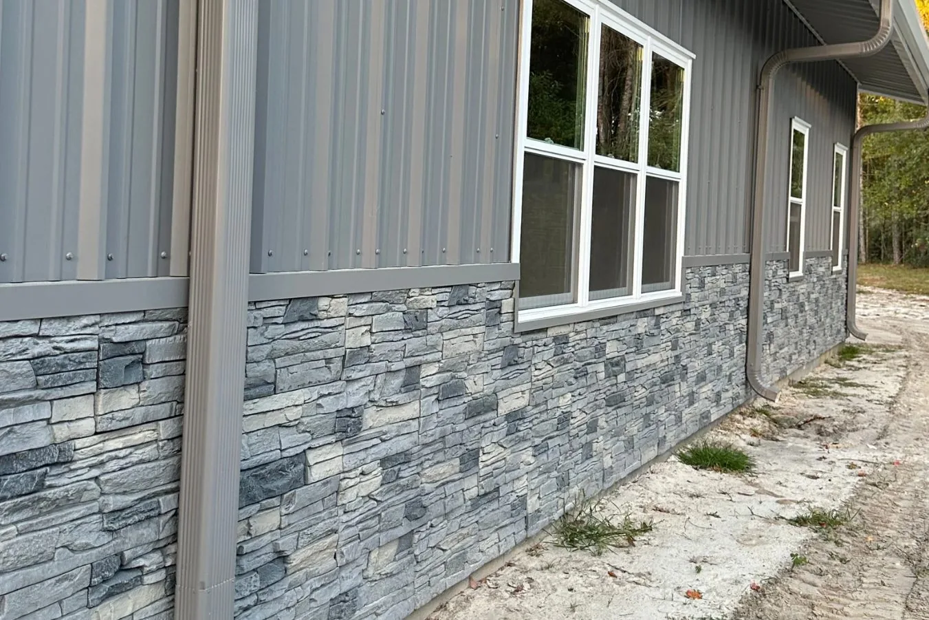 Gray steel sidewall with stacked-stone wainscot running the full length
