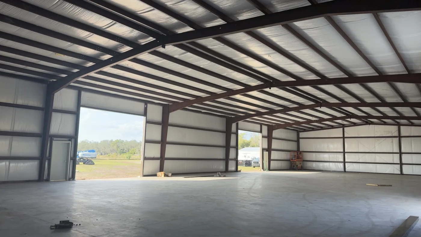 The inside of a Chambliss building at dry-in, roof and walls lined with vinyl-faced insulation blanket between the steel